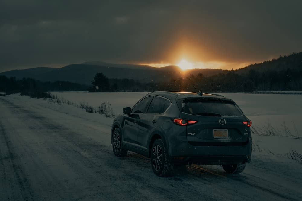 bmw x6 negro en un campo cubierto de nieve durante el día