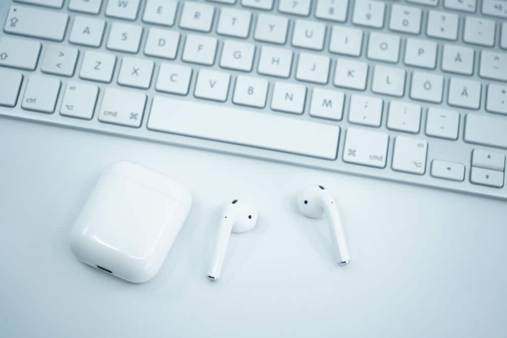 Apple earpods en teclado de computadora blanco