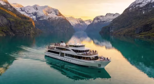 Crucero de lujo Viking navegando por fiordo noruego bajo el sol de medianoche