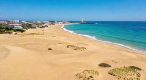 Islas Canarias: el destino perfecto para unas vacaciones con todo incluido Dunas de Maspalomas en Gran Canaria con vista aérea mostrando el contraste entre las dunas doradas y el océano Atlántico