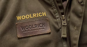 Detalle de etiqueta y logotipo auténtico de parka Woolrich Arctic mostrando bordado de precisión y costuras perfectas