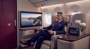 Interior de la Q Suite de Qatar Airways mostrando suites privadas con puertas correderas y pasajero disfrutando del lujo a bordo