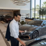 Renting de coches para particulares: cómo funciona y por qué está en auge Hombre examinando coche de renting en concesionario premium
